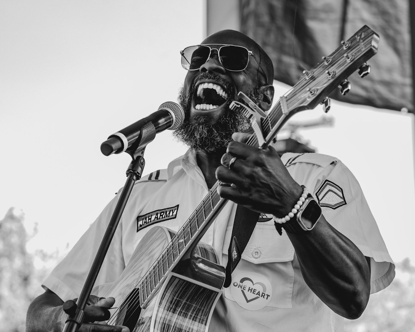 Black-and-white portrait of a singer and guitarist performing outdoors